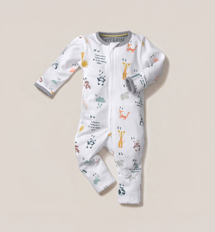 A Kit & Kin alphabet print baby all-in-one made from GOTS-certified organic cotton, designed for newborn comfort and unisex gifting.