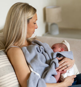 Mum and newborn baby snuggling with a Kit & Kin unisex organic cotton knitted baby blanket - the best baby shower gift for new mums.